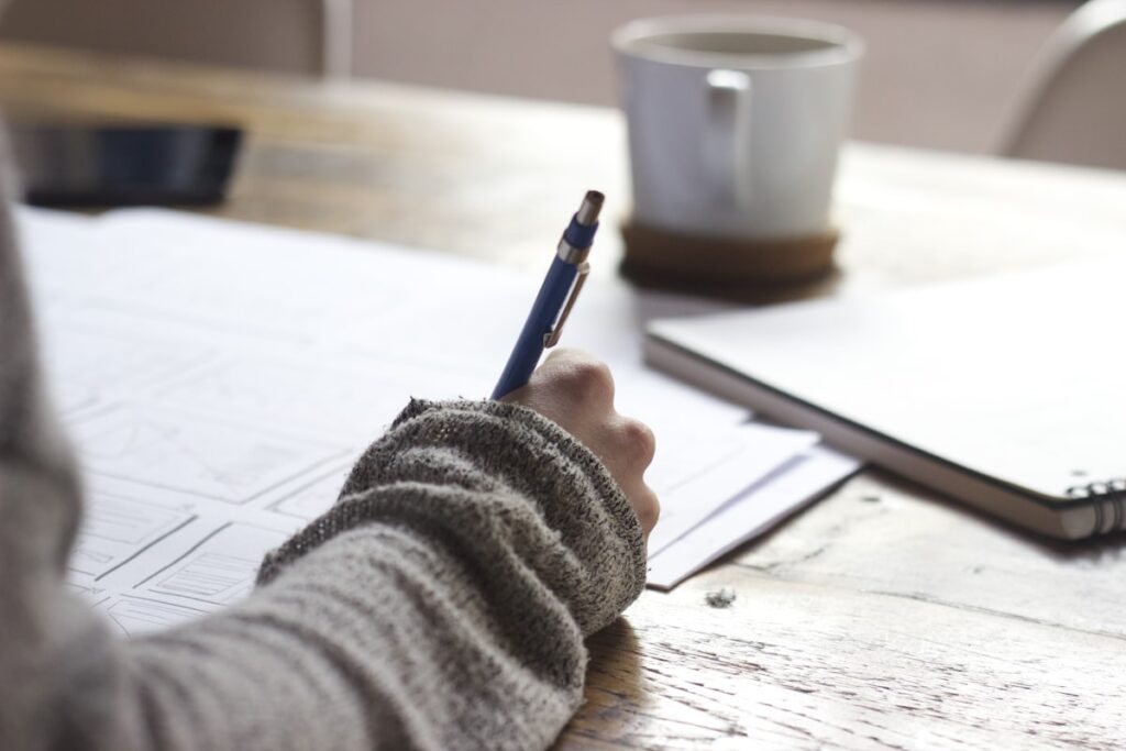 Person writing notes on a form